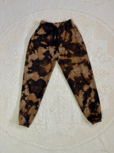 Vintage bleach-dyed sweatpants with a black and brown marbled pattern, elastic waistband, drawstring, and cuffed ankles