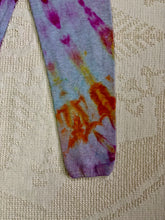 Load image into Gallery viewer, Vintage ice-dyed sweatpants featuring a mix of vibrant magenta, orange, and yellow hues against a light gray base. The pattern radiates outward, creating a bold and unique design. The pants have an elastic waistband and cuffs.
