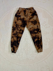 Vintage bleach-dyed sweatpants with a black and brown marbled pattern, elastic waistband, drawstring, and cuffed ankles