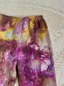 vintage ice-dyed sweatpants featuring a blend of deep magenta, golden yellow, and hints of white, creating a marbled effect. The ice dye technique produces organic, abstract patterns with soft color transitions. The pants have an elastic waistband and a slim fit.